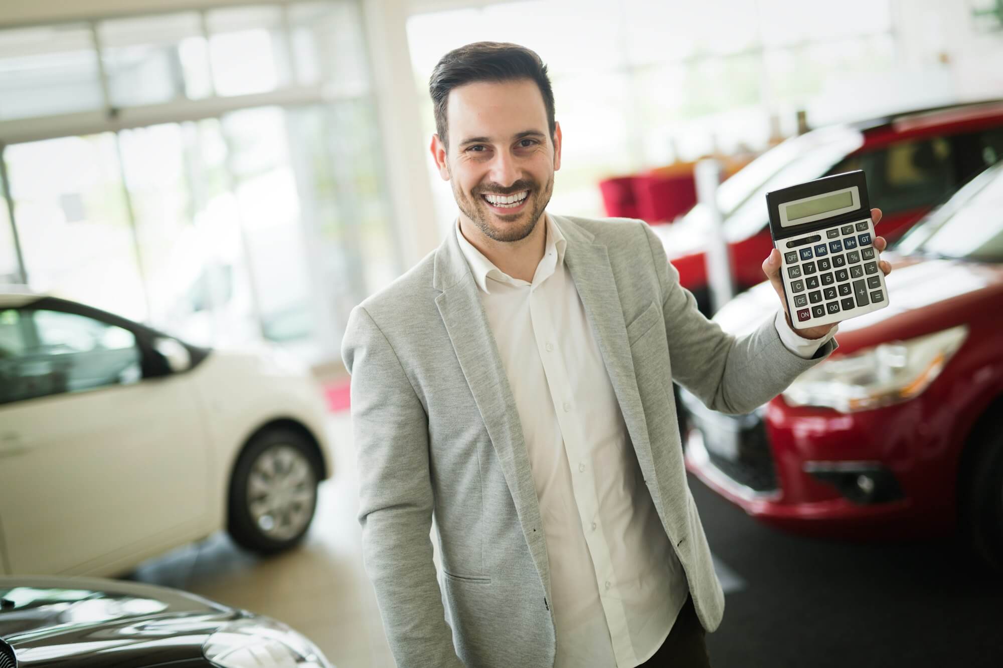 car-salesman-calculating-a-price-at-the-dealership-office.jpg
